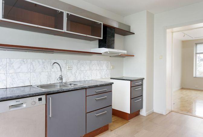 Kjøkkeninnredning med gråmalte slette fronter og laminat benkeplate. 